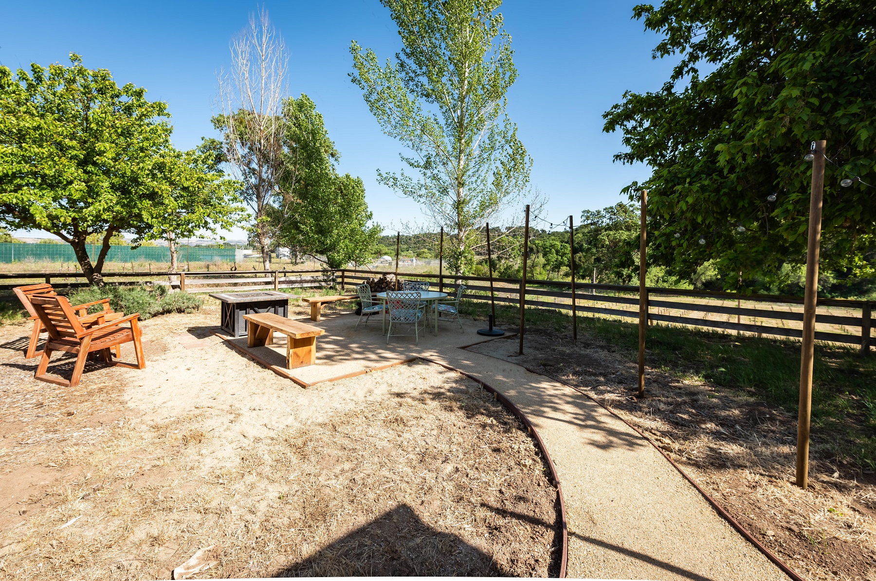 The outside yard has a fire pit and eating area for dining al fresco while enjoying the vineyard views