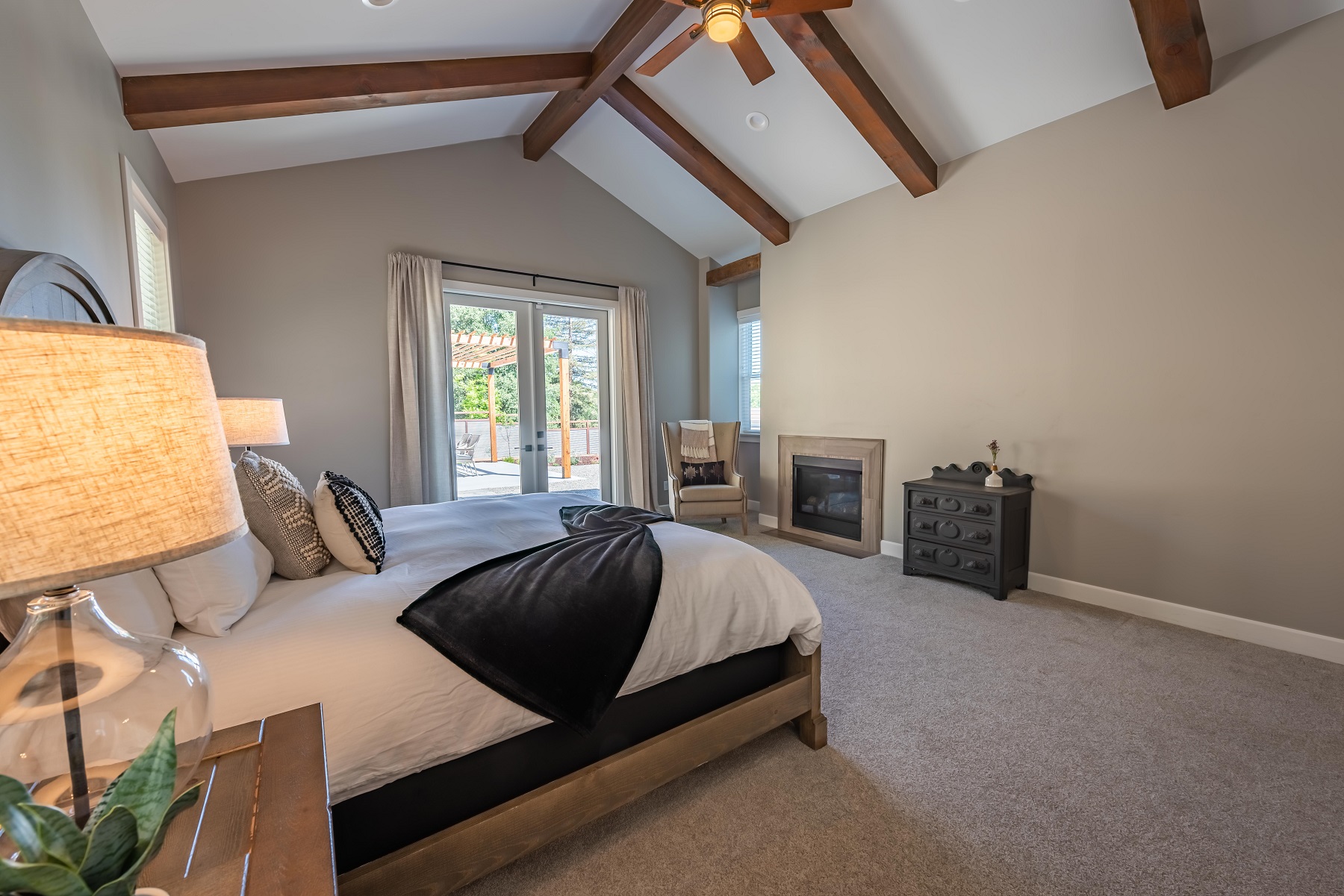 Master bedroom with king bed and ceiling fan.