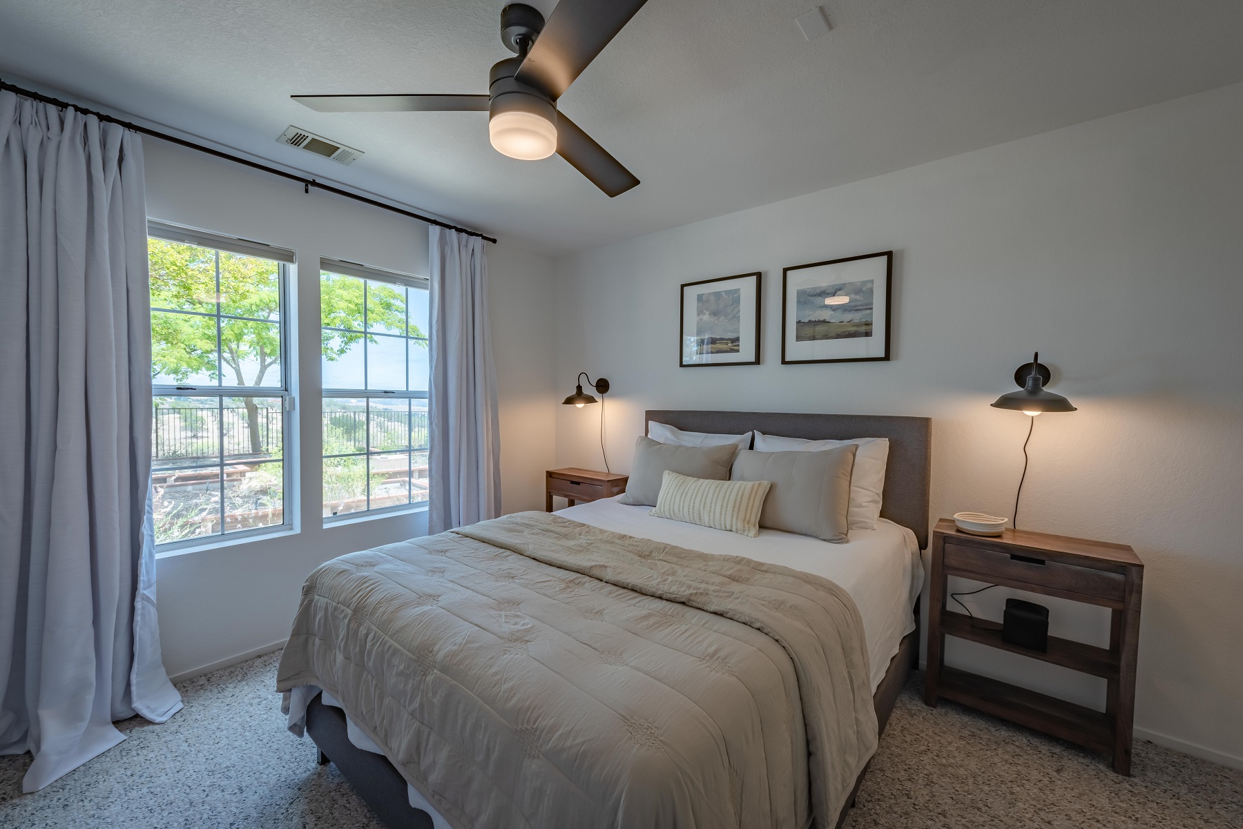 Bedroom 2 with queen bed, ceiling fan and views to the west and overlooking the herb garden